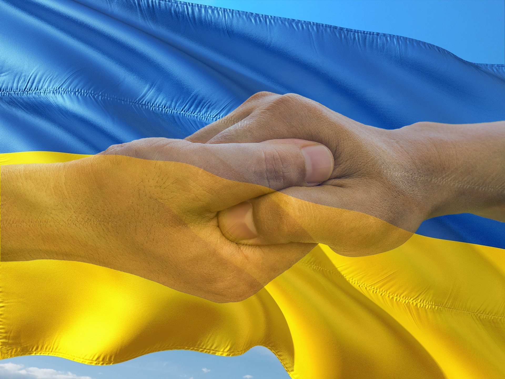 Flaga Ukrainy z dłońmi w uścisku
